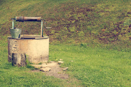 Old well with metal bucket in the villageの写真素材