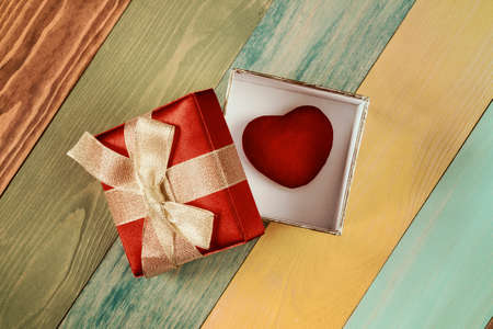Valentine's day background, gift box with  heart inside on color wooden backgroundの写真素材