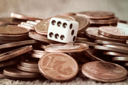 Dice and coin pile on wooden tableの写真素材