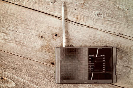 Old radio receiver device on the weathered wooden backgroundの写真素材