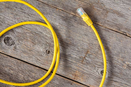Yellow internet cable on the old wooden backgroundの写真素材