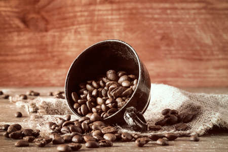 Coffee beans spilled out of the black cup の写真素材