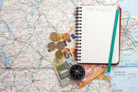 Travel concept with notebook written TRIP PLANNING , compass and money on the  map 