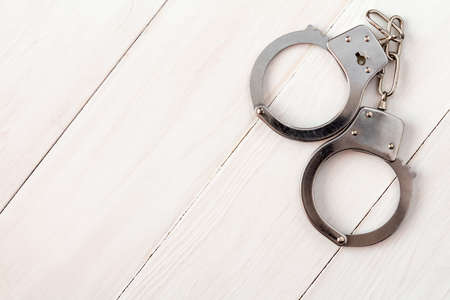 Metal handcuffs on the wooden background,copy-spaceの写真素材