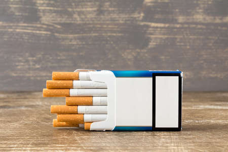 Pack of cigarettes lying on a wooden backgroundの写真素材