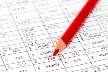 Macro view of red pencil on a report with many digitsの写真素材