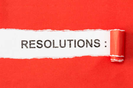 The phrase RESOLUTIONS appearing behind torn paperの写真素材