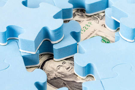 US dollar banknote hidden under puzzle, financial conceptの写真素材