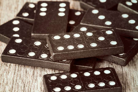 Pile of old dominoes on wooden tableの写真素材