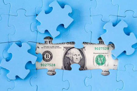 USD banknote hidden under puzzle, financial conceptの写真素材