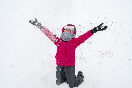 Happy girl playing in snow, winter games 