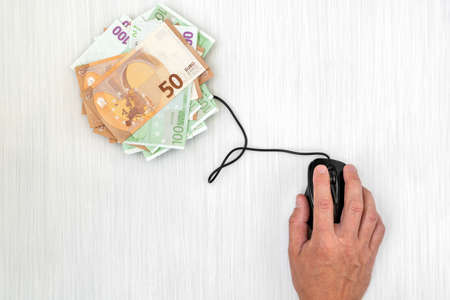 Make money on the Internet. Using computer mouse connected to Euro currencyの写真素材