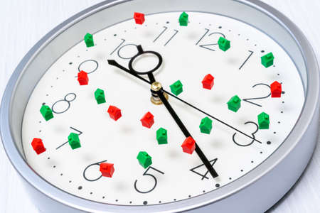 Clock face with small houses. Time to invest to real-estateの写真素材