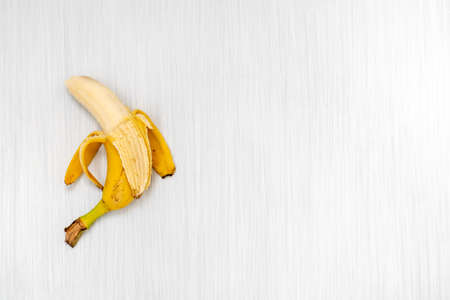 Peeled banana on white wooden background,copy-spaceの写真素材