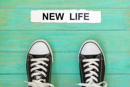 Sneakers standing next to words NEW LIFEの写真素材