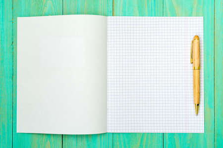Opened squared school notebook with a pen. Copy space.