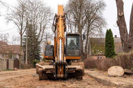 Worker tracke excavator on the street for road repairing