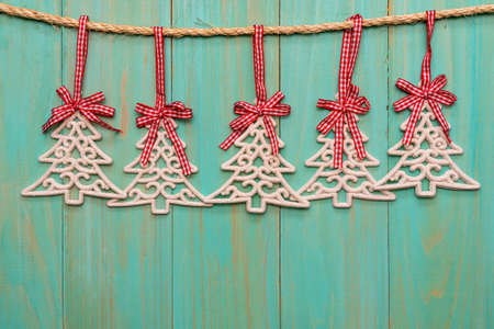 Christmas decorations (fir-tree) hanging over wooden backgroundの写真素材