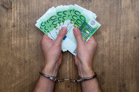 Hands in handcuffs with  money. Concept of arrest for bribery