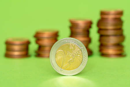 Two euro coin with other coins stacked in the backgroundの写真素材