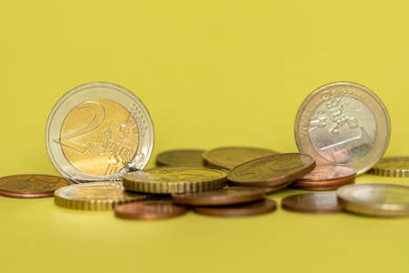 Euro coins in pile on yellow backgroundの写真素材