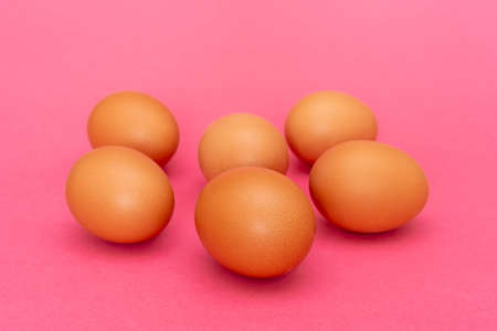 Six brown eggs on pink backgroundの写真素材