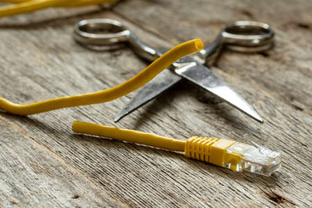 Network cable and scissors on wooden backgroundの写真素材