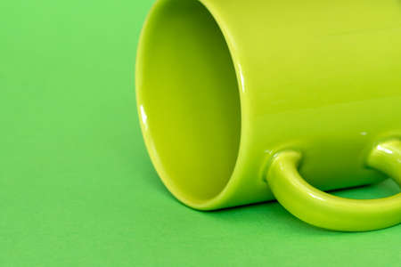 Empty ceramic cup on green backgroundの写真素材
