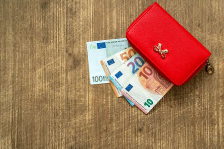 Red female wallet full of euro cash money banknotes. Top view.の写真素材