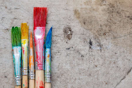 Different paint brushes on dirty background, closeup. Space for text.の写真素材
