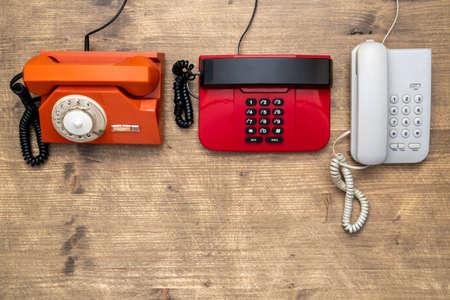 Three old telephones on wooden background. Top view,copy space.の写真素材