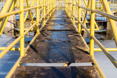 Metal footbridge to the spilway on a small damの写真素材