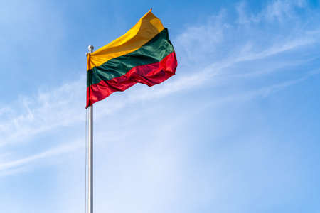 Lithuanian flag waving on the blue sky backgroundの写真素材