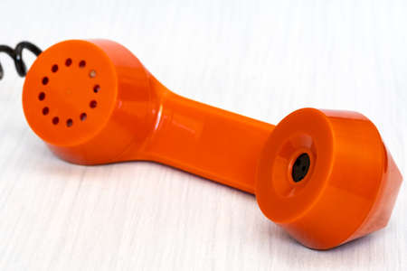 Orange phone receiver close-up. Urgent business. Unsolved problem. Getting in touch.