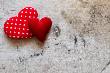 Two cute red hearts on the old canvas background. Copy space.の写真素材