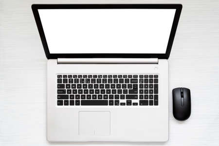Laptop with blank screen and computer mouse on the desk.Top view.