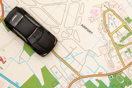 Travel concept - small toy car on the map travelling to airportの写真素材