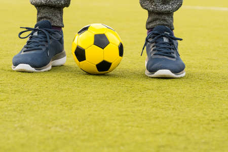 Feet of player with ball on artificial turf soccer fieldの写真素材