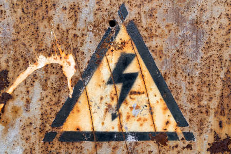 Old, rusty high voltage warning signの写真素材