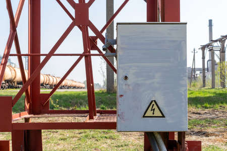 Electric box on the train station, with oil tanks on background