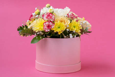 Flower arrangement in a hat box , a pot of pink for a girl on a gift