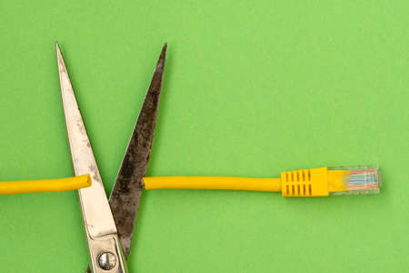 Steel scissors cut the yellow network cable connector.Internet censorship conceptの写真素材