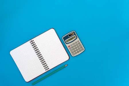 Personal organizer,calculator and  pencil on blue background