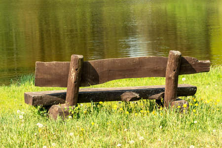 Empty wooden bench with lake view
