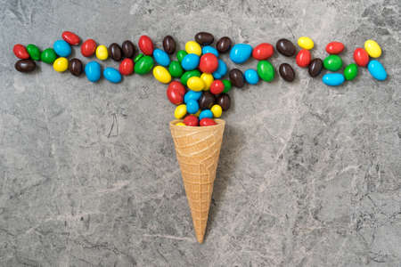 Wafer horn with colored candy on a stone background. Top view, copy-space.の写真素材