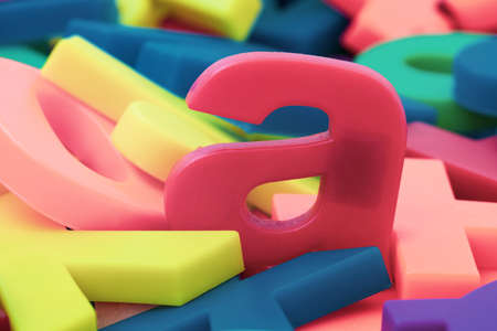 Pink letter "a" on the pile of colorful plastic lettersの写真素材