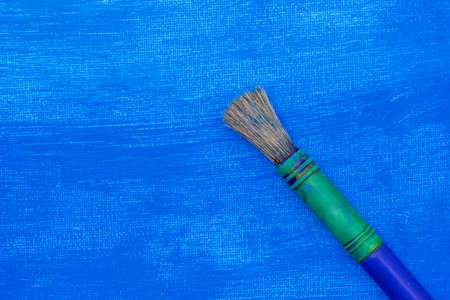 Paint brush on a blue painted canvas. Copy spaceの写真素材