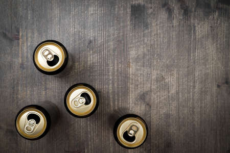 Opened Cans of beer on wooden table. Top view