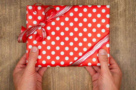 Hands holding craft paper gift box  as a present for Christmas, new year, valentine day or...
