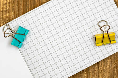 Blank notebook with blue and yellow paper clipの写真素材